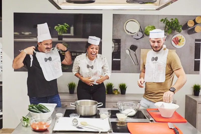 tre chef amatoriali che cucinano nella cucina di Corefab Milano