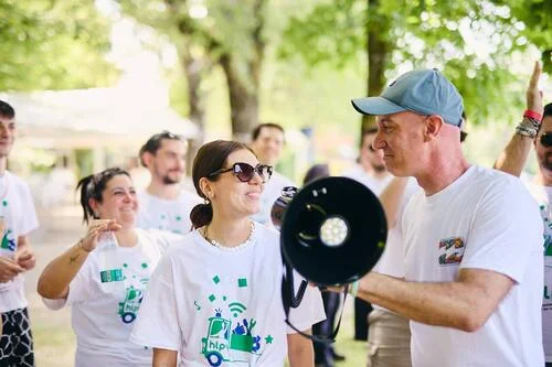 Team di lavoro con maglia bianca in un bosco con megafono