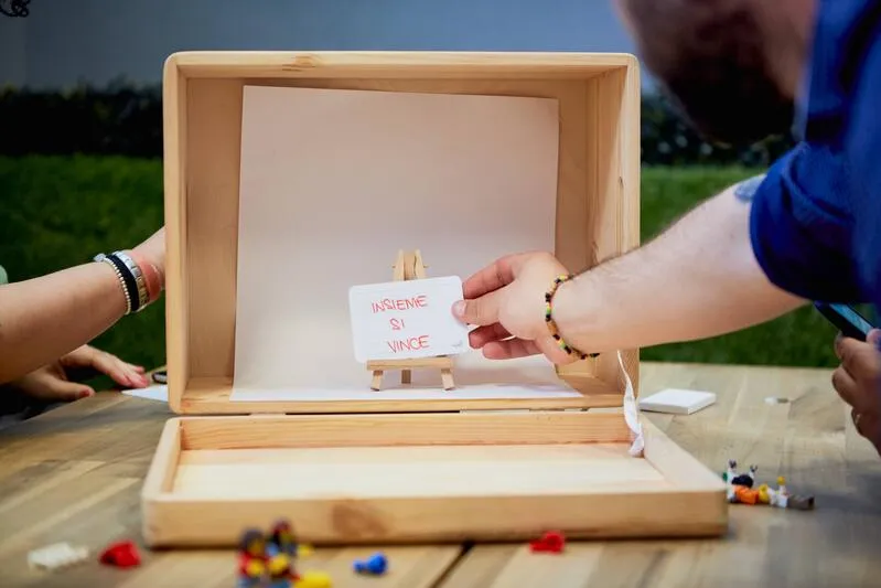 Wood box used as a movie set, one hand holding a white card