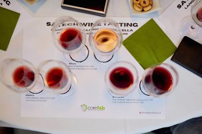 Tavolo con dei fogli e dei bicchieri di vino rosso e bianco
