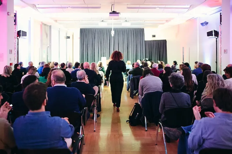 Sala di un teatro con molte persone sedute sulle poltrone
