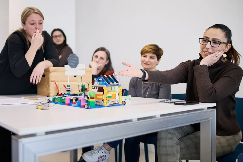 colleghi di lavoro seduti al tavolo che realizzano lavoro con lego