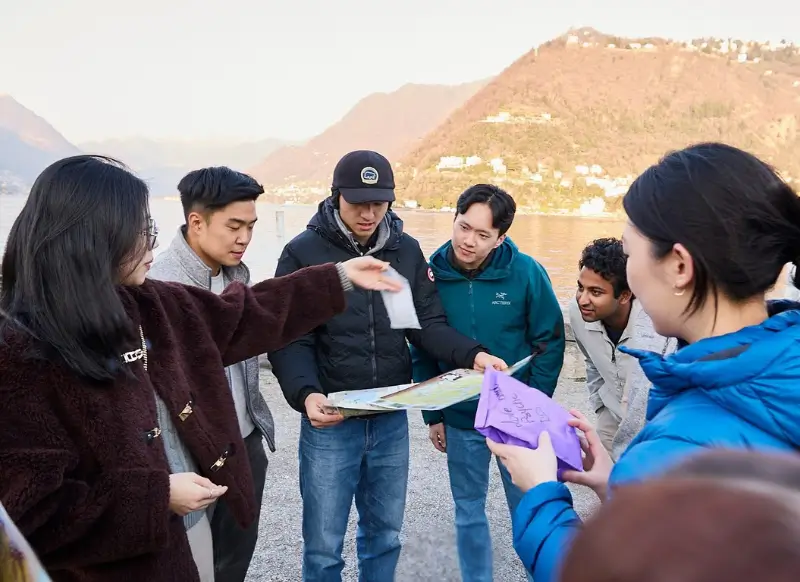 Colleghi di lavoro sul Lago di Como che guardano la mappa della caccia al tesoro