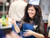 Ragazza del team che sorride in cucina con cappello da cuoco