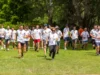 Dipendenti aziendali che partecipano a una corsa di team building in un parco verde in Lombardia, indossando magliette personalizzate.