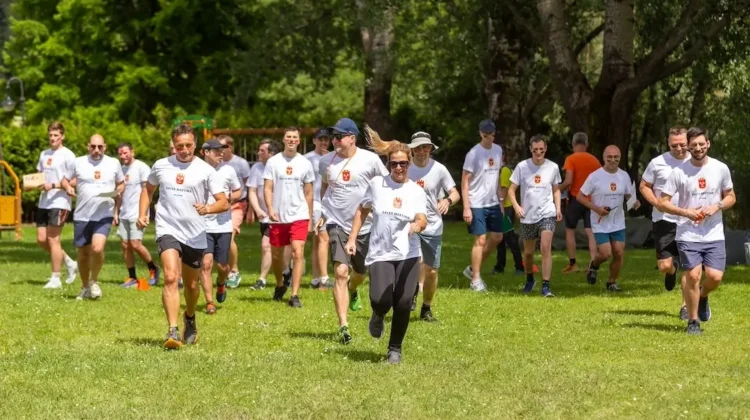 Dipendenti aziendali che partecipano a una corsa di team building in un parco verde in Lombardia, indossando magliette personalizzate.