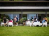 Partecipanti all’evento di team building HPLY seduti in gruppo nel giardino di Villa Repui a Besozzo, mentre conversano in un momento di networking informale.