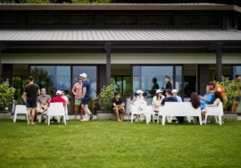 Partecipanti all’evento di team building HPLY seduti in gruppo nel giardino di Villa Repui a Besozzo, mentre conversano in un momento di networking informale.