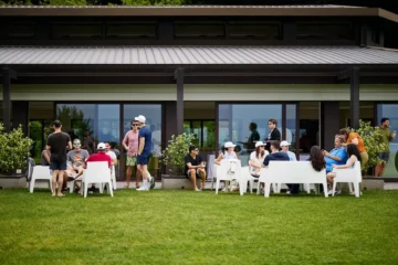 Partecipanti all’evento di team building HPLY seduti in gruppo nel giardino di Villa Repui a Besozzo, mentre conversano in un momento di networking informale.