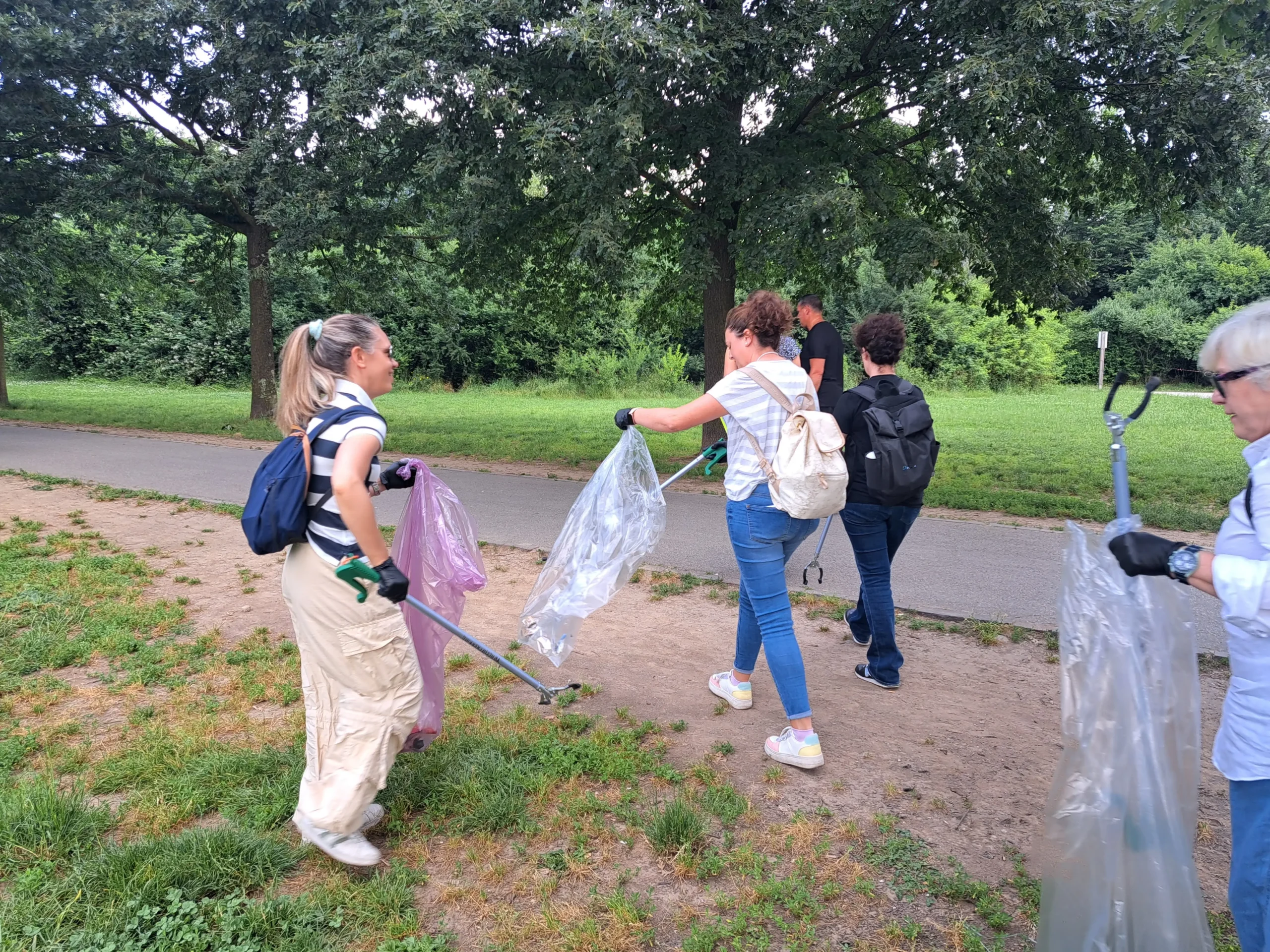 Collaboratori aziendali raccolgono rifiuti lungo i sentieri del Parco Nord, in un’attività di team building eco e volontariato aziendale firmata Corefab.