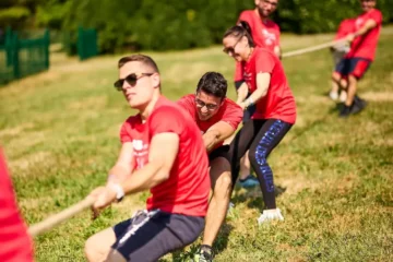 team di colleghi che fa tiro alla fune durante un team building