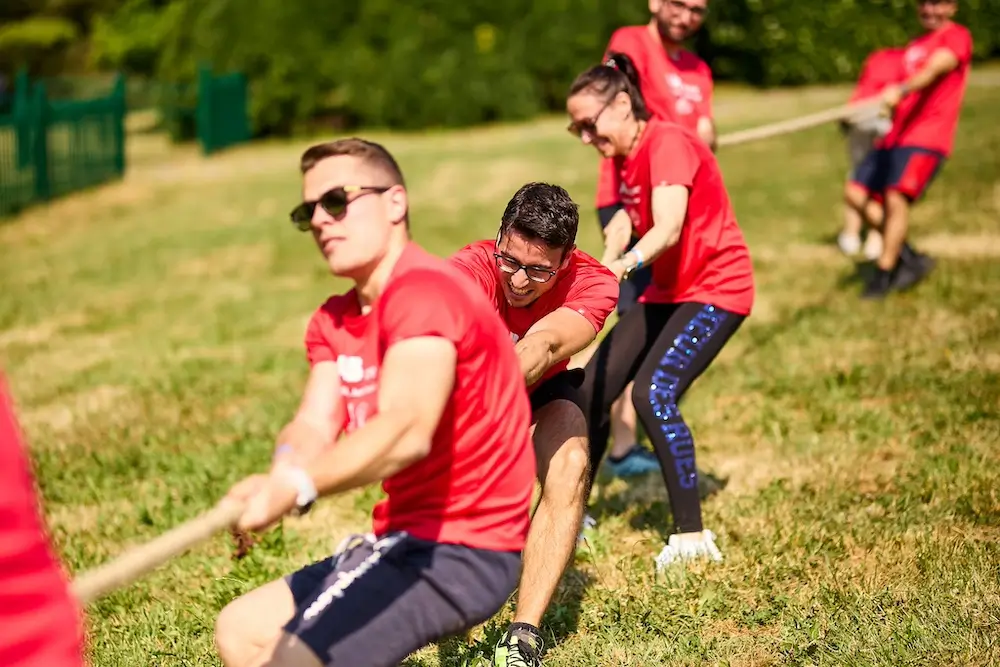 team di colleghi che fa tiro alla fune durante un team building