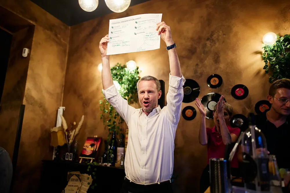 Manager che alza al cielo un foglio celebrando il proprio team durante un evento di Natale aziendale, esempio di team building che valorizza le persone.