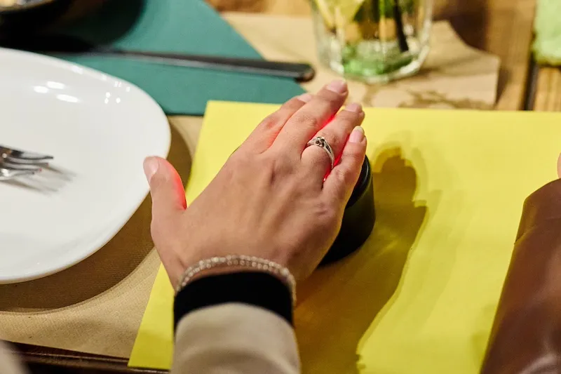 Mano destra con anello che preme il pulsante rosso