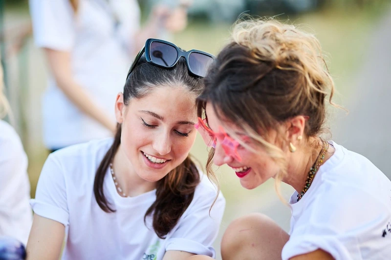 Due colleghe che sorridono e si divertono durante un team building aziendale estivo