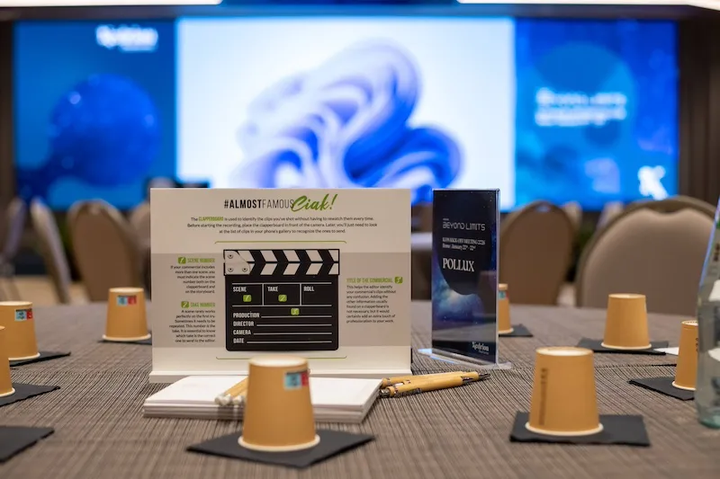 Tavolo allestito per team building AlmostFamous a Roma con ciak cinematografico, penne e materiali per attività di gruppo