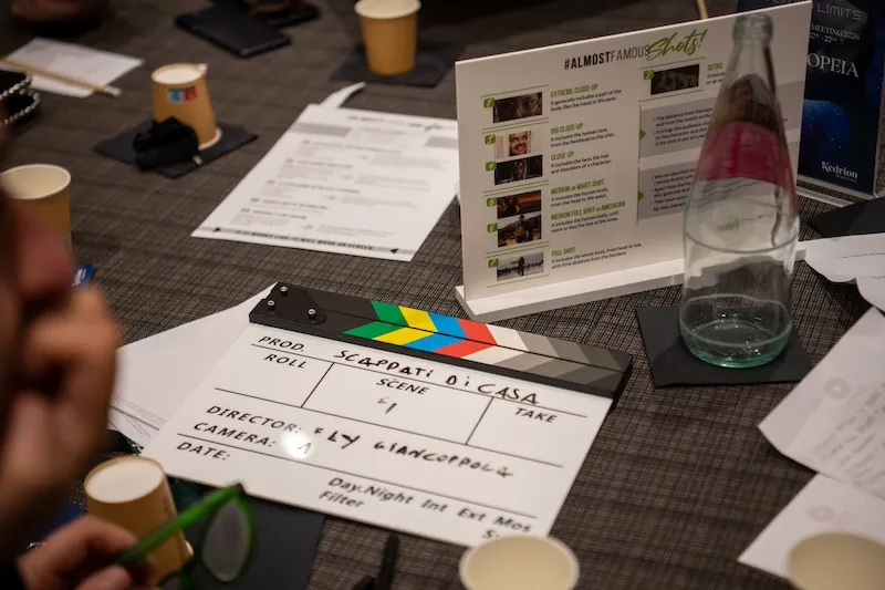 Ciak e materiali creativi sul tavolo durante team building cinematografico a Roma