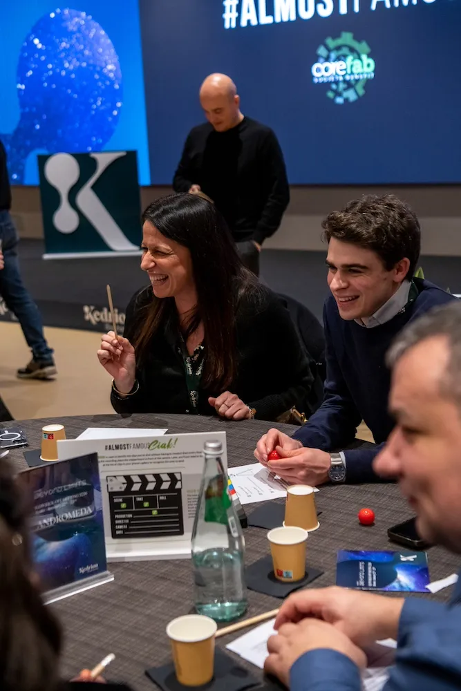 Partecipanti sorridenti durante attività di gruppo al tavolo nel team building AlmostFamous a Roma