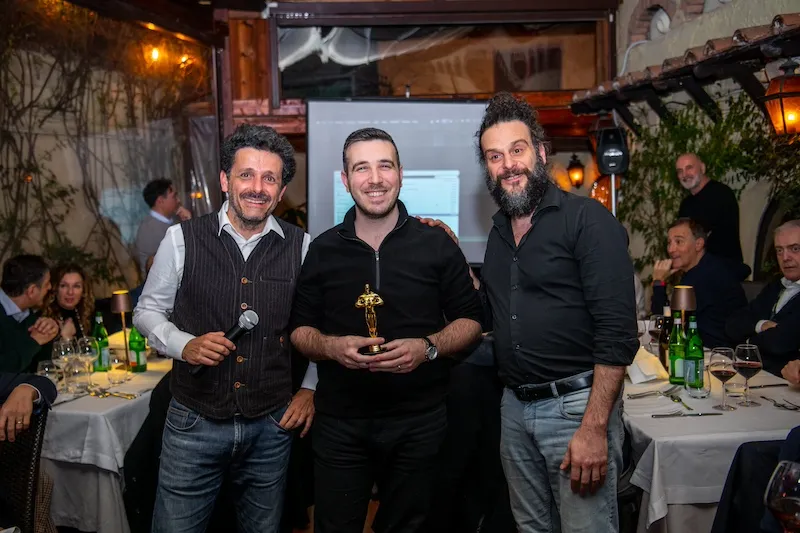 Vincitori con trofeo Oscar durante cena di premiazione dopo team building a Roma