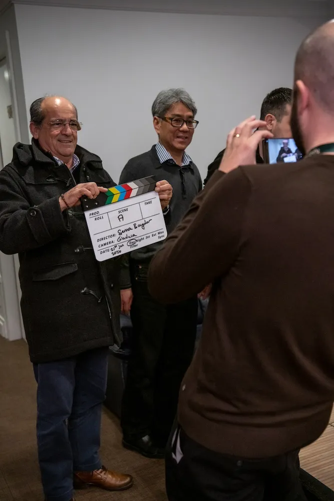 Partecipanti che utilizzano ciak cinematografico durante riprese per team building a Roma