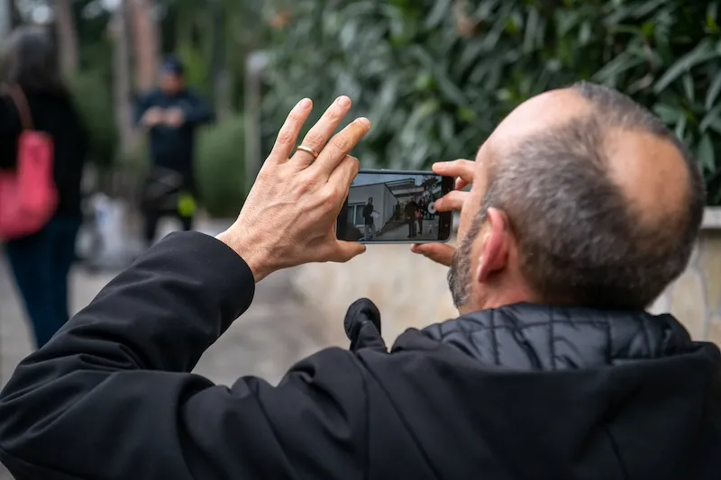 Partecipante che effettua riprese con smartphone durante team building all'aperto a Roma