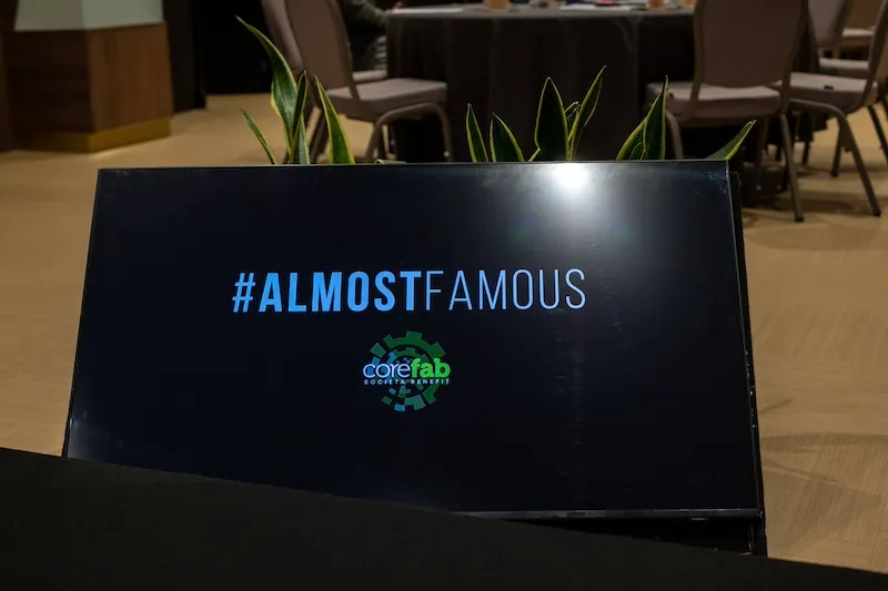 Schermo con logo AlmostFamous e CoreLab per evento di team building aziendale a Roma