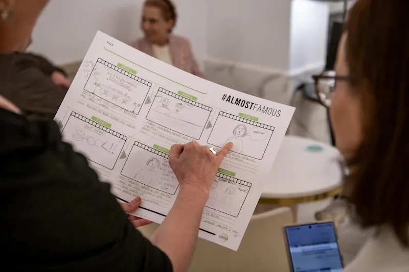 artecipante che mostra storyboard durante attività creativa di team building a Roma