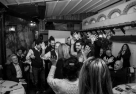 Foto in bianco e nero di un gruppo di colleghi di lavoro che ballano facendo team building e sostenibilità sociale