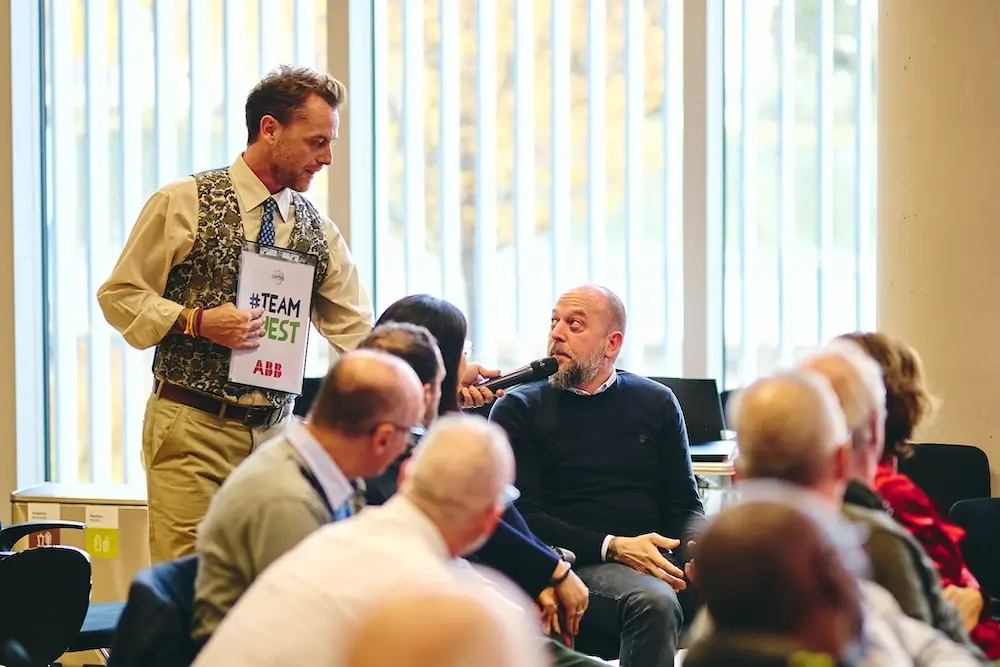 team building solidale con un presentatore che intervista i colleghi di lavoro durante il team building