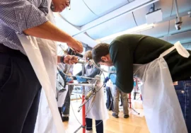 colleghi intenti a restaurare una vecchia bicicletta durante un team building organizzato da Corefab