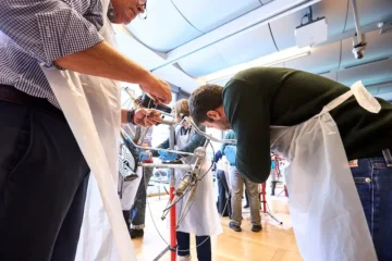 colleghi intenti a restaurare una vecchia bicicletta durante un team building organizzato da Corefab